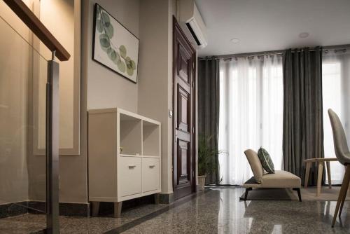 a living room with a white cabinet and a chair at Apartamento en Centro Histórico con patio Romano in San Lorenzo de El Escorial