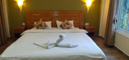 a bedroom with two beds with a towel animal on the bed at Hotel hornbill in Sauraha