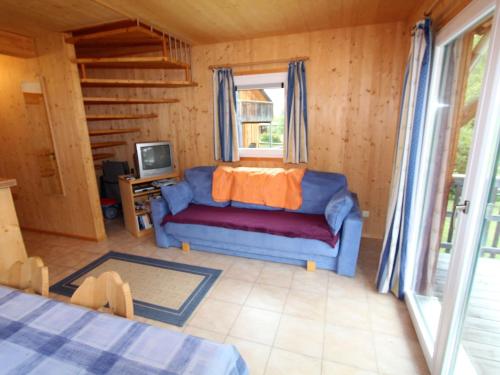 a living room with a couch and a tv at Chalet in Stadl an der Mur Styria near ski area in Stadl an der Mur