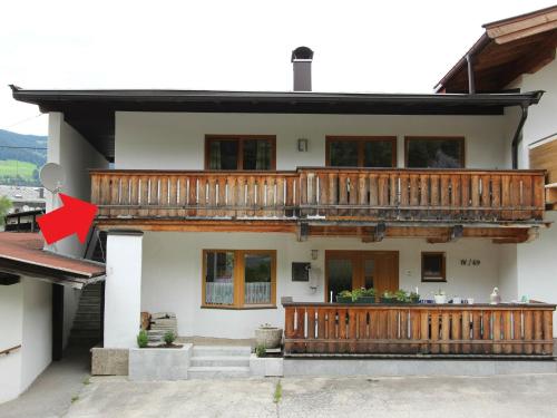 ブリクセン・イム・ターレにあるBoutique Apartment in Brixen with Mountain Viewの赤矢のバルコニー付き家