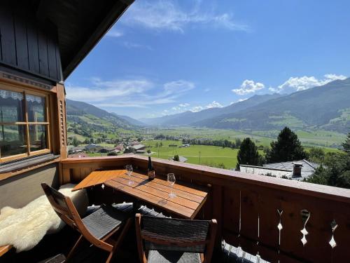 d'une table et de chaises en bois sur un balcon avec vue sur les montagnes. dans l'établissement Chalet in ski area in Piesendorf, à Piesendorf