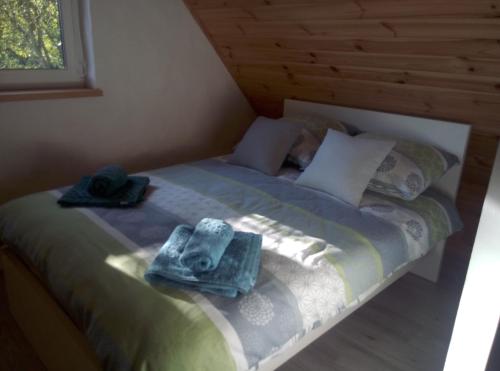 a bed with two hats and towels on it at Domek Jana in Mrągowo