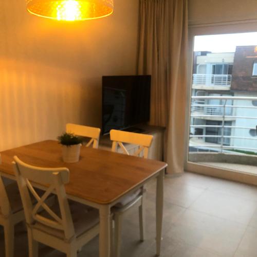 Una mesa de comedor con sillas y un televisor. en ANGEL, en Bredene
