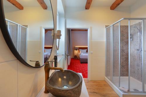 a bathroom with a sink and a mirror at Landhotel & Brauhaus Prignitzer Hof in Pritzwalk