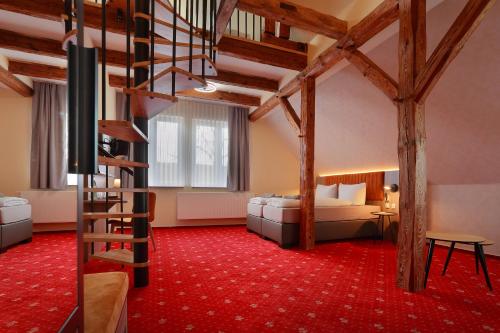 Habitación de hotel con cama y escalera en Landhotel & Brauhaus Prignitzer Hof, en Pritzwalk