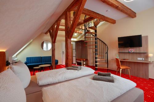ein Wohnzimmer mit 2 Betten und einer Treppe in der Unterkunft Landhotel & Brauhaus Prignitzer Hof in Pritzwalk