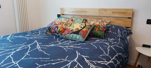 a bed with a blue comforter and some pillows at Casa Dolcitalia a Gardaland con piscina in Ronchi