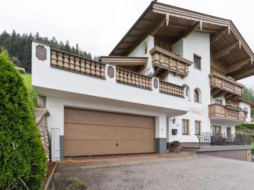 a large white house with a garage at Quaint Apartment in Hainzenberg near Horbergbahn in Hainzenberg