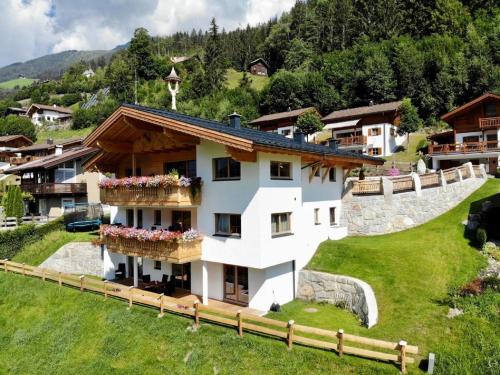 duży biały dom z kwiatami na balkonach w obiekcie Chalet in Wald near Ski Slopes w mieście Wald im Pinzgau