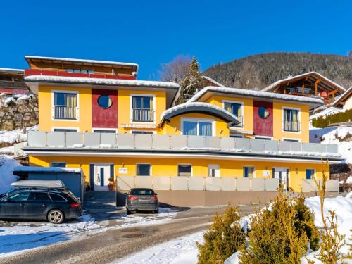 a yellow building with cars parked in front of it at Chalet in Piesendorf with sauna in Piesendorf