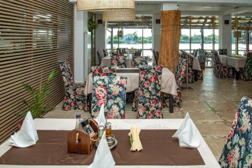 um restaurante com mesas e cadeiras num quarto em Pensiunea Paradise Delta House em Fîntîna Dulce