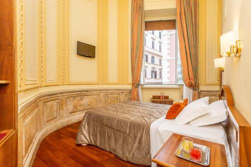 a hotel room with a bed and a table at Hotel Medici in Rome