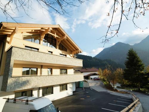 a building with a parking lot next to a mountain at Luxury Apartment in Salzburg with terrace in Alpendorf