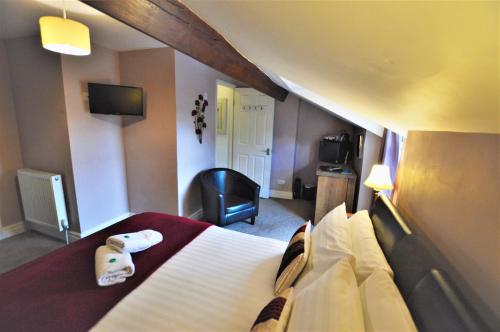 a hotel room with a bed and a television at All Seasons Rest in Windermere