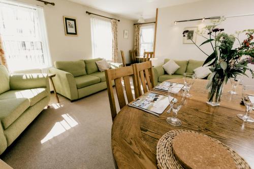 a living room with a wooden table and a couch at Galwad y Mor in St. Davids