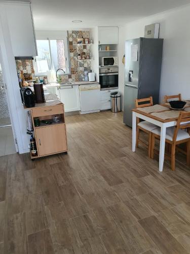 a kitchen with a table and a refrigerator and a table and chairs at Residencial T2 no Parque Verde in Quinta do Conde