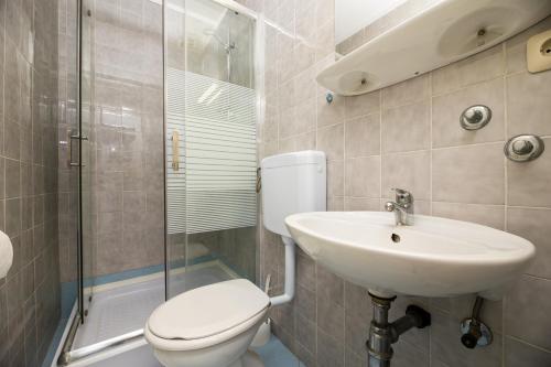a bathroom with a toilet and a sink and a shower at Meliores Rooms in Šilo