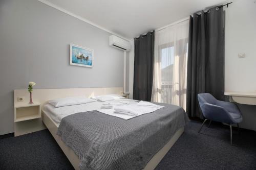 - une chambre avec un lit, une chaise et une fenêtre dans l'établissement Meliores Rooms, à Šilo