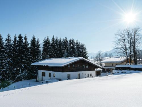 フラッハウにあるApartment near Flachau with mountain viewの雪山の上に雪が積もった家
