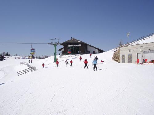 a group of people skiing down a snow covered slope at Apartment in Fresach near Ski Slopes in Fresach