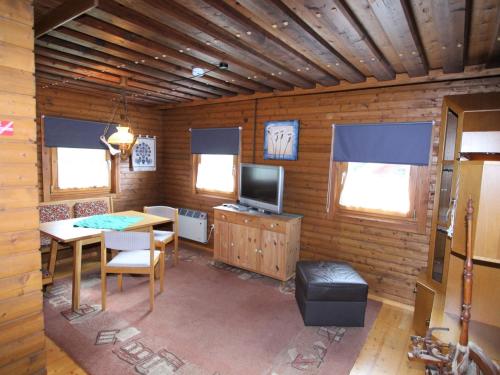 a room with a table and a television in a cabin at Modern holiday apartment in a restored farmhouse in Fresach Carinthia in Fresach