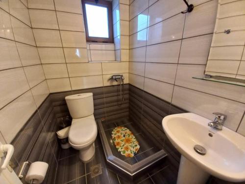 a bathroom with a toilet and a pizza in the floor at Arjana & Nelaj Apartments in Ksamil