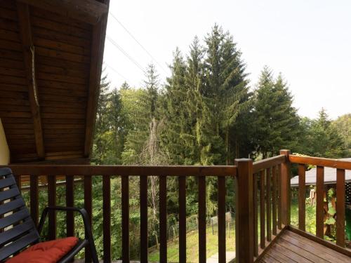 a porch of a cabin with a chair and trees at Apartment near the Koralpe ski area 
