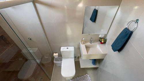 uma casa de banho com um WC, um lavatório e um espelho. em Sua casa em Foz do Iguaçu. Apt encantador e aconchegante na Vila A. em Foz do Iguaçu