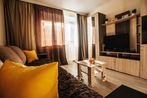 a living room with a couch and a television at Апартаменты в 10мин от м4 in Voronezh