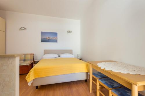Un dormitorio con una cama amarilla y una mesa en Guest House Luce, en Dubrovnik