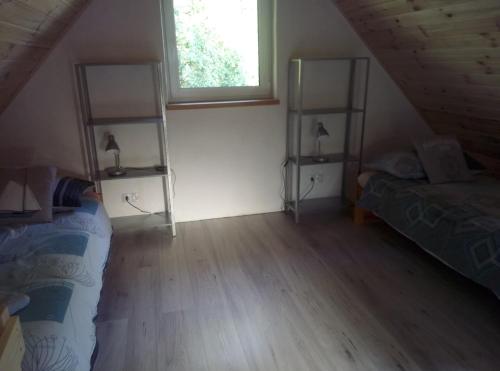 a attic room with a bed and a window at Domek Jana in Mrągowo