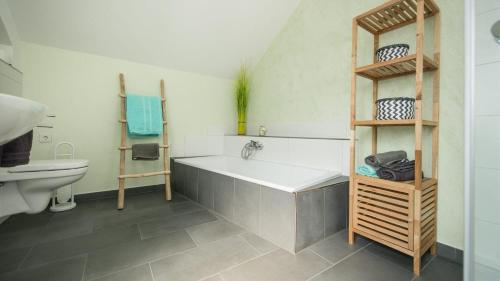 a bathroom with a bath tub and a sink at Ferienwohnung / Haus Hunsrückblick in Hochstetten-Dhaun