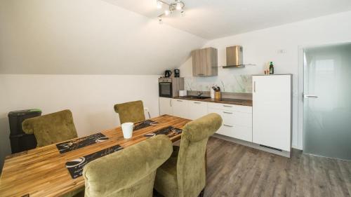 a kitchen with a long wooden table and chairs at Ferienwohnung / Haus Hunsrückblick in Hochstetten-Dhaun