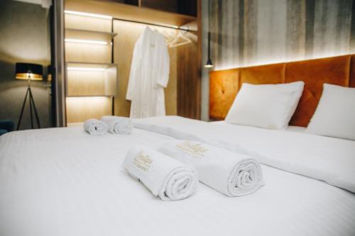 2 Betten in einem Hotelzimmer mit Handtüchern darauf in der Unterkunft Boutique Luxury Apartments in Kragujevac