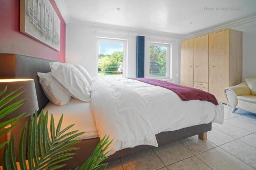 a bedroom with a large white bed with a window at Résidence Dolce Vita in Waimes