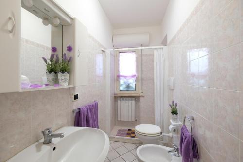 un bagno bianco con lavandino e WC di Marina 2 Pineto Vacanza a Pineto