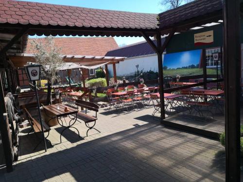 a patio with tables and chairs in a building at Landhotel & Brauhaus Prignitzer Hof in Pritzwalk