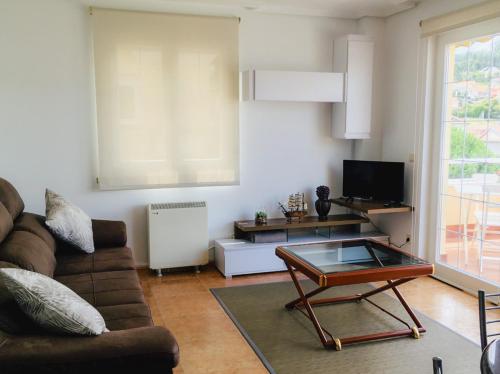 ein Wohnzimmer mit einem Sofa und einem Couchtisch in der Unterkunft Apartamento Praia de Quenxe in Corcubión