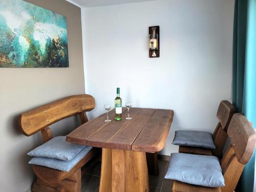 una mesa de madera con 2 sillas y una botella de vino en Ferienhaus Unstrutblick, en Memleben