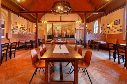 a dining room with a wooden table and chairs at Landhotel & Brauhaus Prignitzer Hof in Pritzwalk
