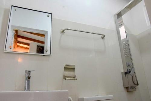 baño con espejo y lavabo en Hotel H2O en Gampola