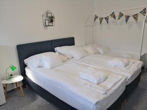 a large bed with white sheets and white pillows at Hőforrás Hotel in Gyula