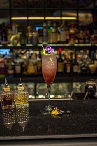 a drink with a flower in a glass on a counter at Hôtel Roi de Sicile - Rivoli in Paris