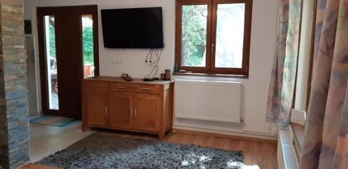 a living room with a flat screen tv on the wall at New and comfortable two bedroom house in Gărâna
