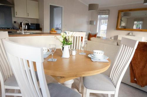 a dining room table with chairs and a kitchen at Hollicarrs - Bumblebee Lodge in York