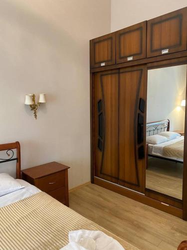a bedroom with a large wooden cabinet with a mirror at Beridze Apartment in Tbilisi City