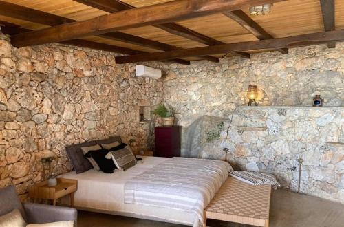 ein Schlafzimmer mit einem Bett in einer Steinmauer in der Unterkunft Kamaroules Sea Front in Argostoli