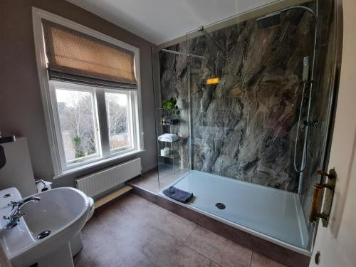 uma casa de banho com um chuveiro, uma banheira e um lavatório. em The Priory em Hereford