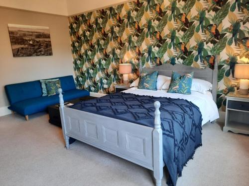 a bed in a bedroom with a blue and white bedspread at The Priory in Hereford