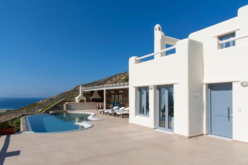 a villa with a swimming pool and the ocean at Naxos Rock Villas in Stelida